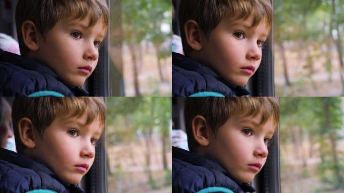 悲伤的年轻乘客。一个好奇的小男孩在火车上看着窗外的特写镜头。面部表情。糟糕的一天。这个男孩在旅行时透