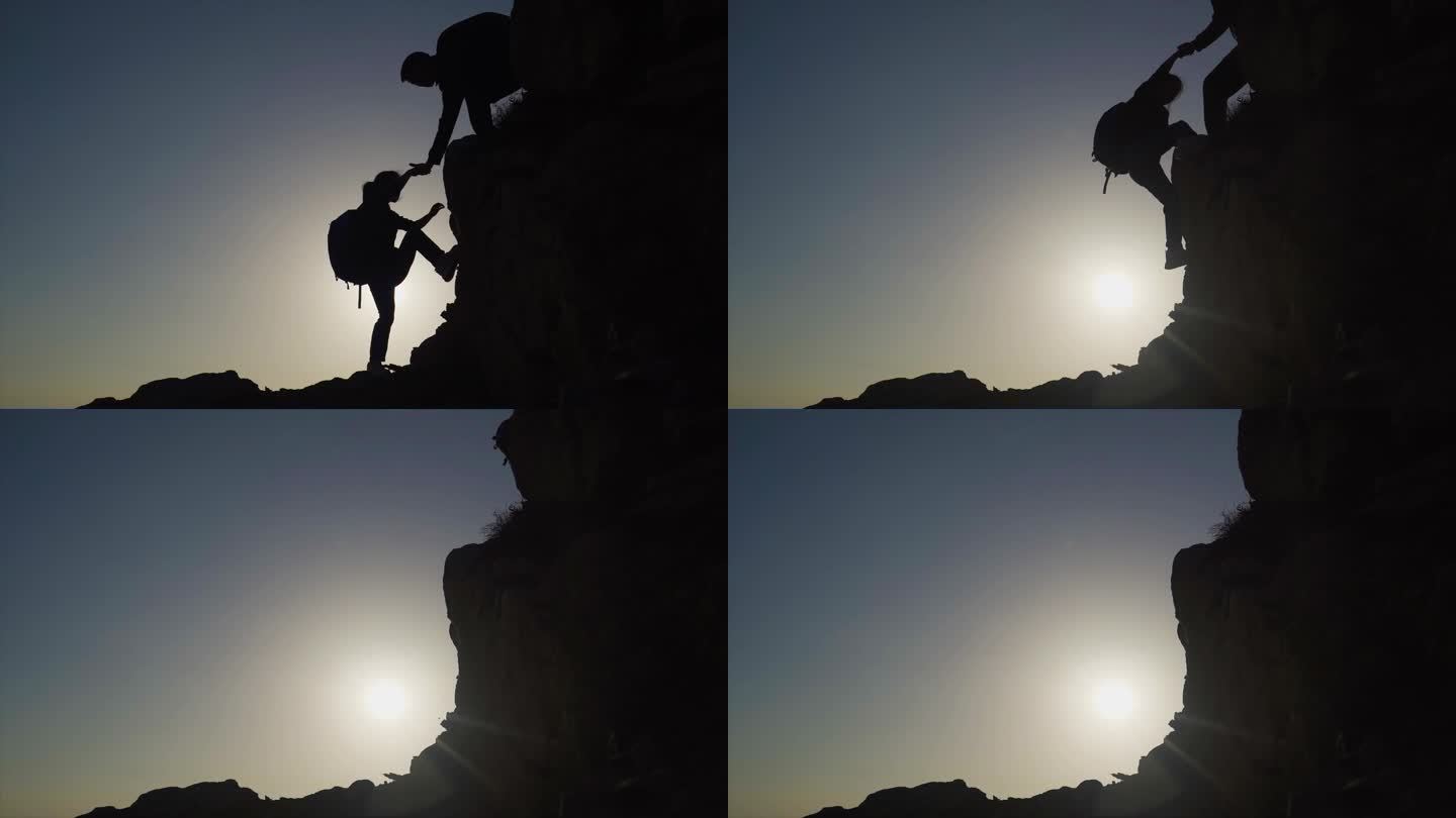 团队手拉手登上山顶逆光爬山人物剪影探险者