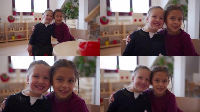 两个可爱的学龄前女孩在幼儿园教室里拥抱
