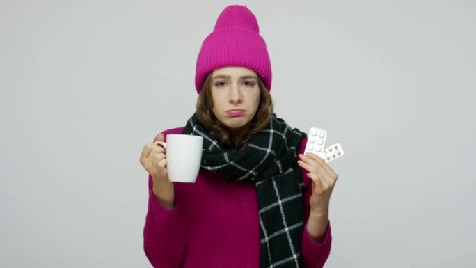不健康的女人在冬天的帽子和围巾看起来不高兴生病滑稽的表情，咳嗽