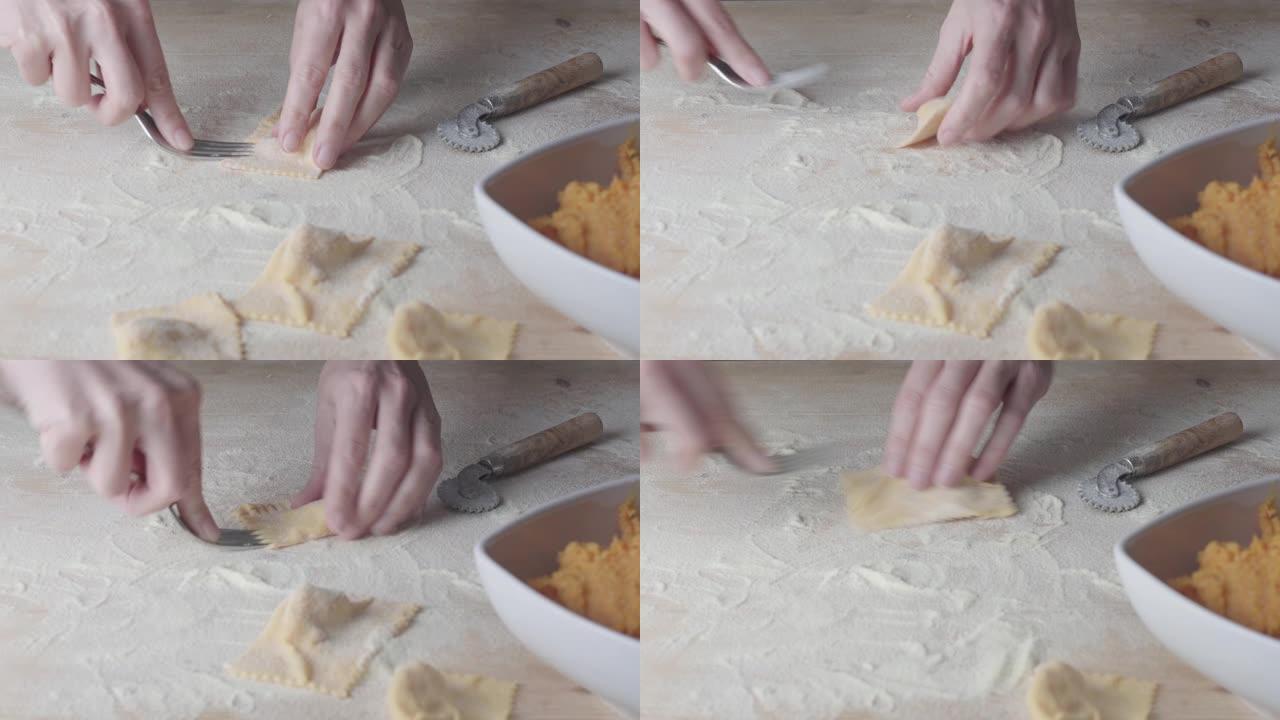 特写制作馄饨素食自制意大利面。家庭主妇厨师用叉子 “tortelli di zucca” 关闭，传统