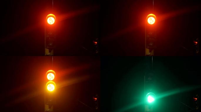 在夜晚变换红琥珀色和绿色交通灯
