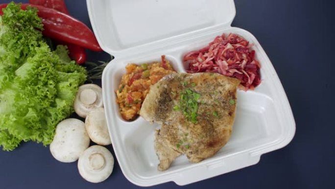将外卖食品包装在聚苯乙烯泡沫塑料盒中。新鲜送货套餐，鸡胸肉，米饭，蔬菜和沙拉