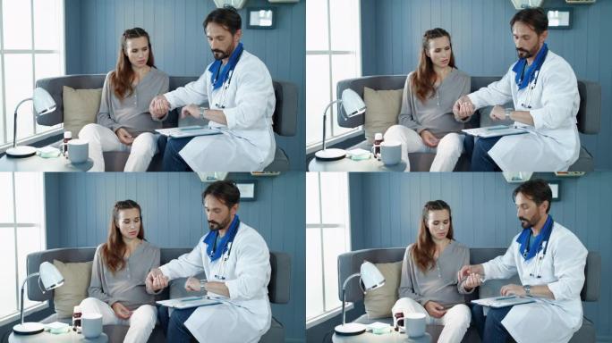 男性医生用孕妇手上的手表检查脉搏。
