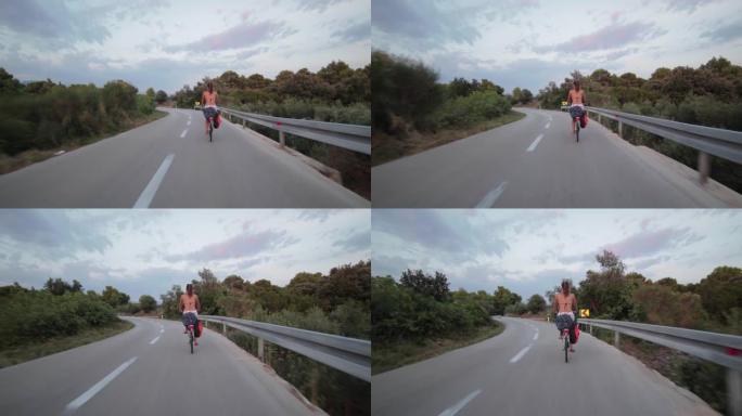 在赫瓦尔岛的一条空旷的道路上骑自行车的年轻女子