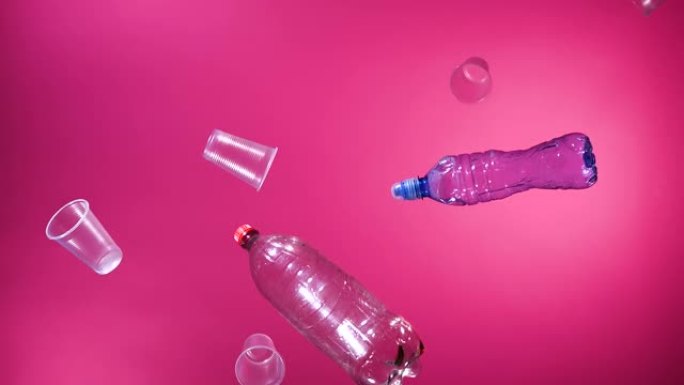 粉色背景的塑料瓶和塑料杯