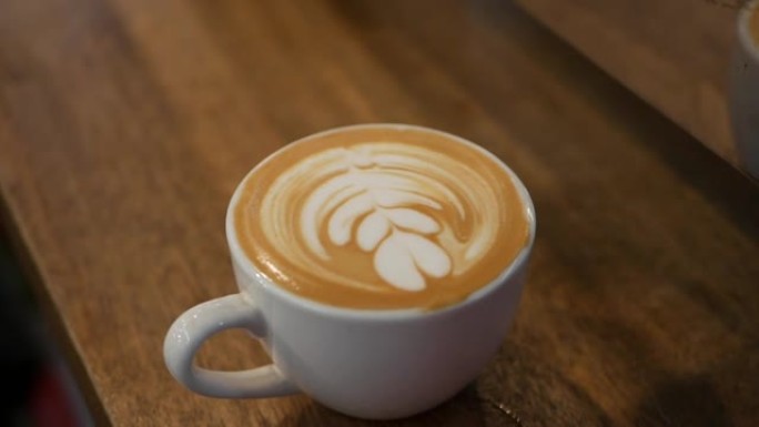 一杯带有拿铁艺术的咖啡。咖啡师在牛奶泡沫上做了一个美丽的艺术。特写