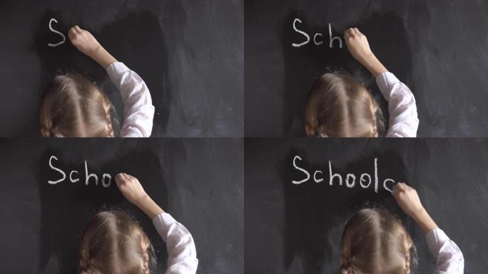小女孩在黑板上写下学校这个词。
