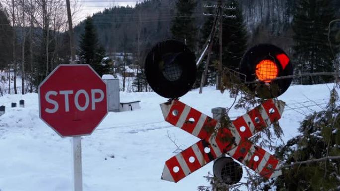 冬天，森林中的铁路道口红色闪烁的交通信号灯。火车经过