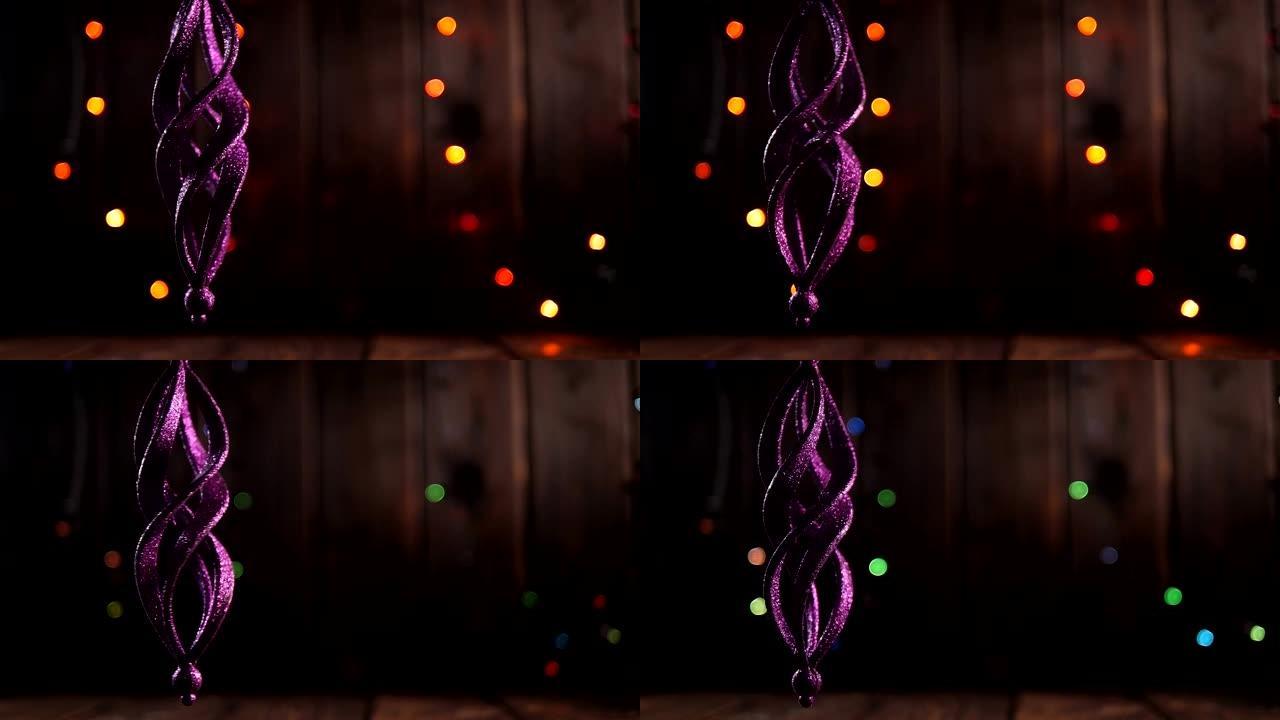 木制背景上的圣诞紫色闪亮玩具，闪烁彩灯。