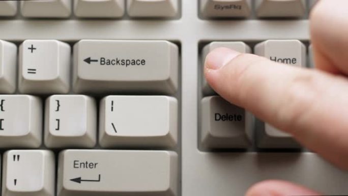 男性手指按下白色键盘上的插入按钮。慢动作和宏观视图