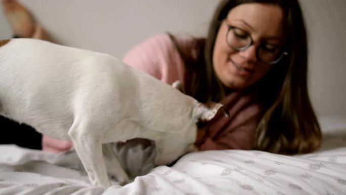 Young woman playing with her puppy Jack Russell te