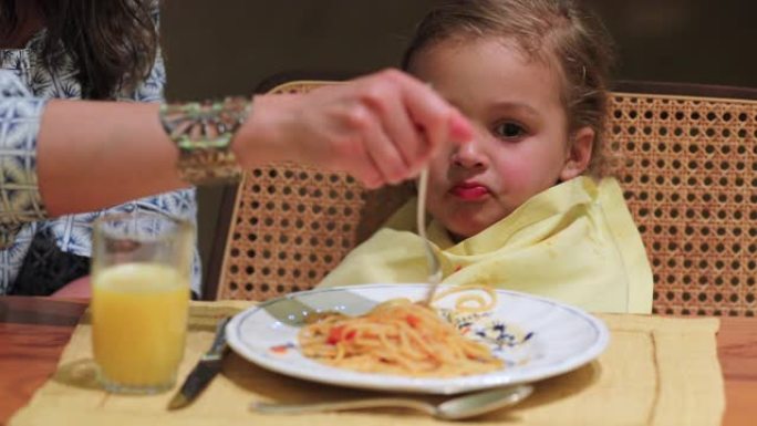 晚餐吃意大利面条的孩子妈妈喂孩子食物