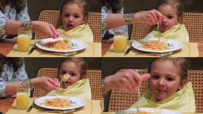 晚餐吃意大利面条的孩子妈妈喂孩子食物