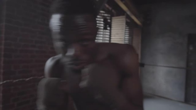 年轻的黑人拳击手在搏击俱乐部练习防御动作
