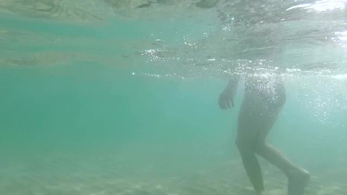 水下摄影。男孩的腿去海边。