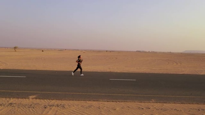 沙尘暴后，金发碧眼的女人穿着黄色正宗背包，在沙质道路上寻找。沙漠中的旅行冒险。