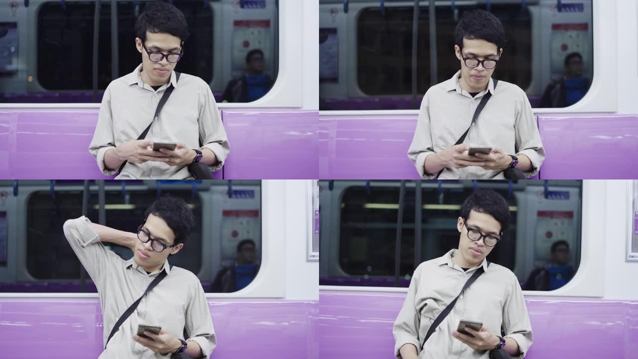 年轻的亚洲男子在乘坐地铁时使用智能手机