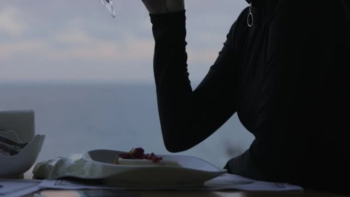 女人在海景餐厅喝白葡萄酒