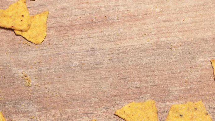 停止运动有害快餐，从木桌上取墨西哥玉米片。吃了美味的黄色玉米片