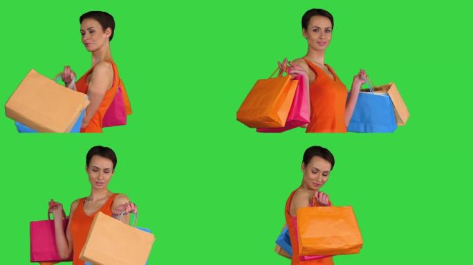 时尚年轻女士拿着购物袋，在绿色屏幕上转身，色键
