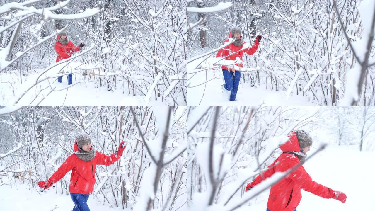 女旅行者跳过白雪覆盖的森林。雪挂在树枝上，一碰就碎了。