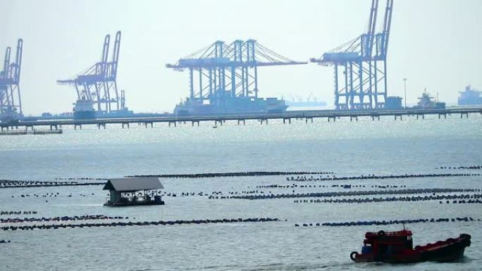 海港背景中的船驱动通道牡蛎养殖场和起重机