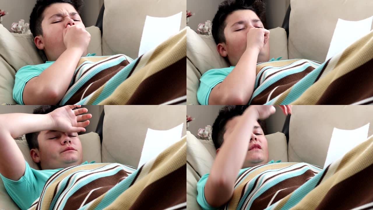 生病的小男孩在毯子覆盖的沙发上咳嗽