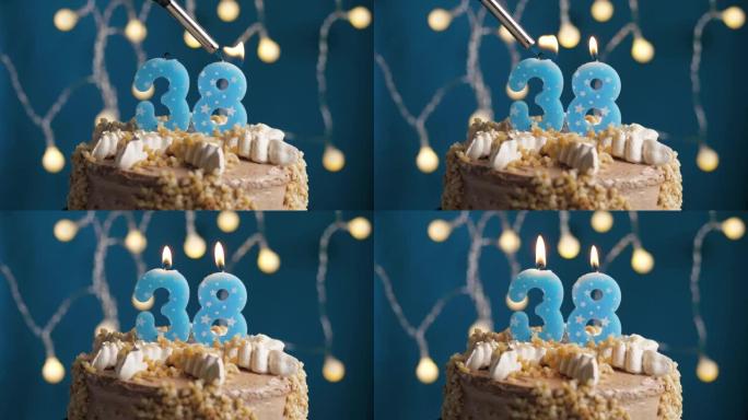 蓝色背景上有38号蜡烛的生日蛋糕。蜡烛着火了。慢动作和特写视图