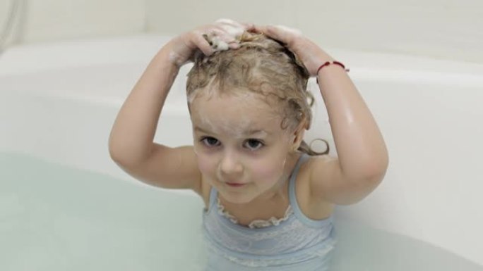 可爱的金发女孩穿着泳衣洗澡。小孩洗头