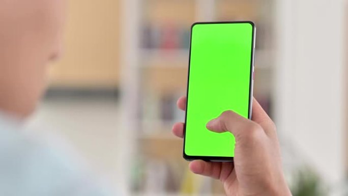 Chroma Key，年轻的非洲裔美国人使用绿色智能手机屏幕