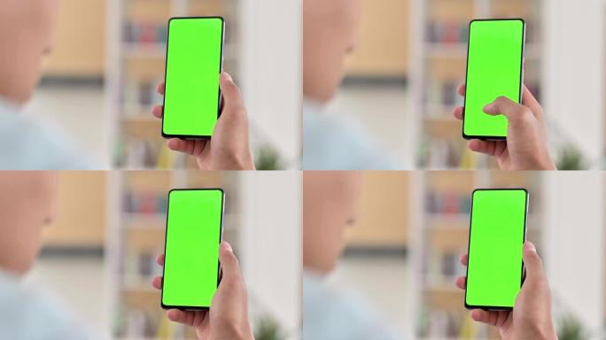 Chroma Key，年轻的非洲裔美国人使用绿色智能手机屏幕
