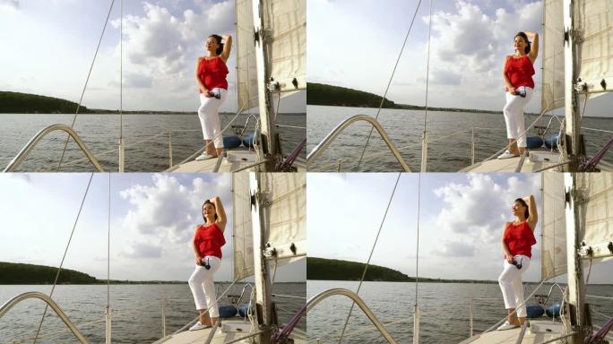 穿着红色和白色衣服的微笑女人在帆船上放松