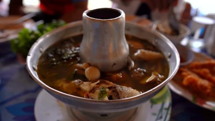 美味的麻辣汤烹饪食物，餐桌上锅里的热汤和模糊的背景，人们吃饭和晚餐中的美味