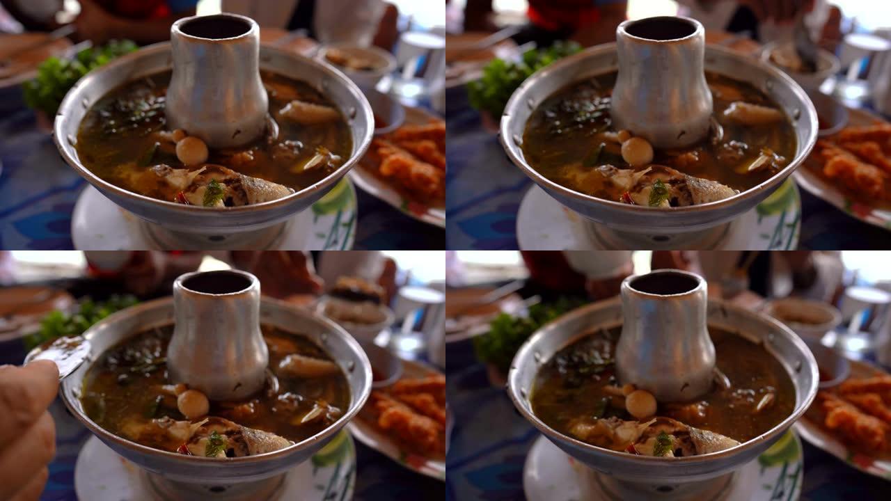 美味的麻辣汤烹饪食物，餐桌上锅里的热汤和模糊的背景，人们吃饭和晚餐中的美味