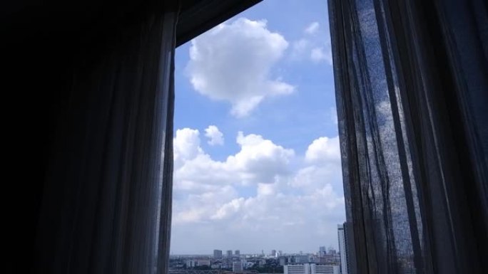蓝天白云的城市景观，从带窗帘的玻璃窗看