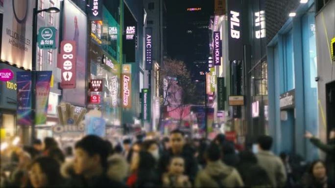 晚上在韩国繁忙的购物街地区散步的人群城市生活