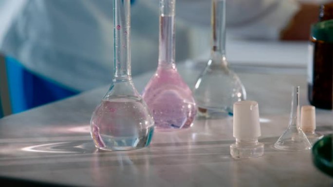 实验室助理将试剂放入桌上有液体的烧瓶中