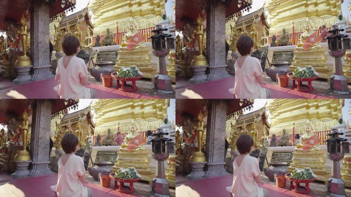 亚洲妇女在寺庙中与佛陀祈祷