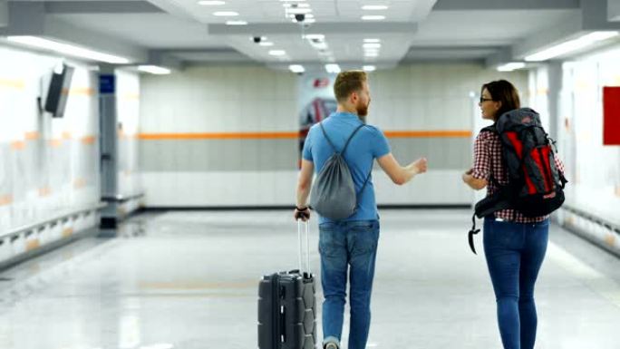 机场的年轻夫妇。外国人出差背影拉着行李箱