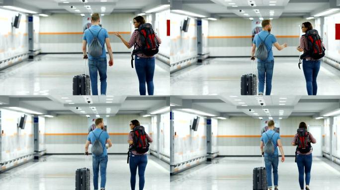 机场的年轻夫妇。外国人出差背影拉着行李箱