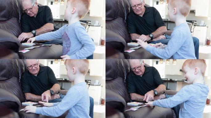 小男孩在家检疫时与祖父打牌游戏