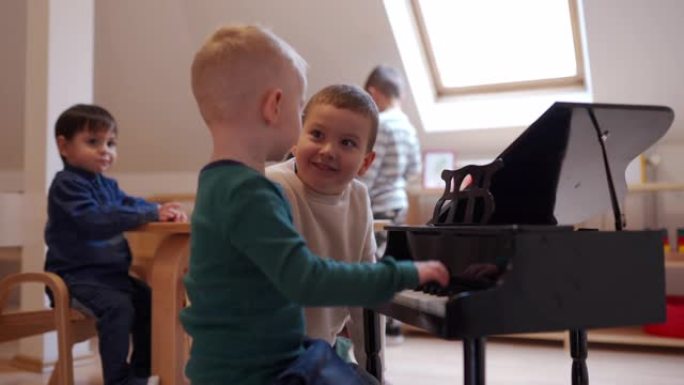 两个男孩在幼儿教室里弹迷你钢琴
