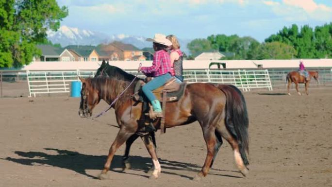 年轻的牛仔女郎在牧场上骑马