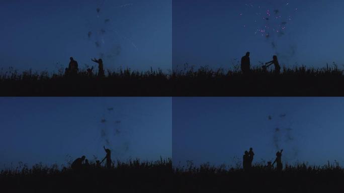 一家四口正在用烟花在夏日的夜空中快乐地跳跃