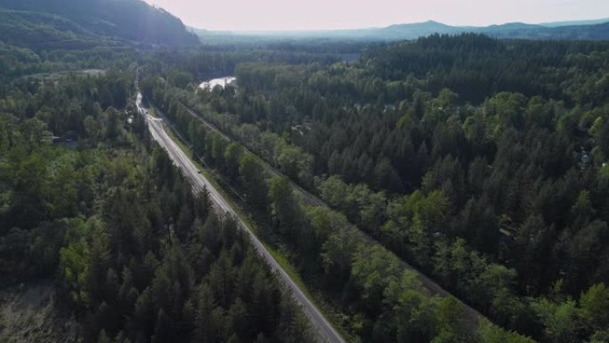 华盛顿州金条附近山区之间森林中繁忙的2号高速公路的鸟瞰图。无人机视频与前向摄像机运动。
