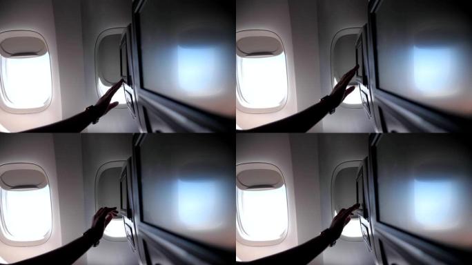 女性手触摸飞机特写中的座椅靠背屏幕