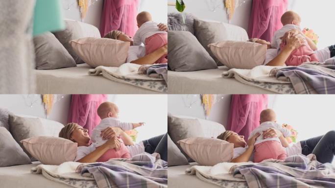婴儿和她的妈妈在午睡前在床上拥抱
