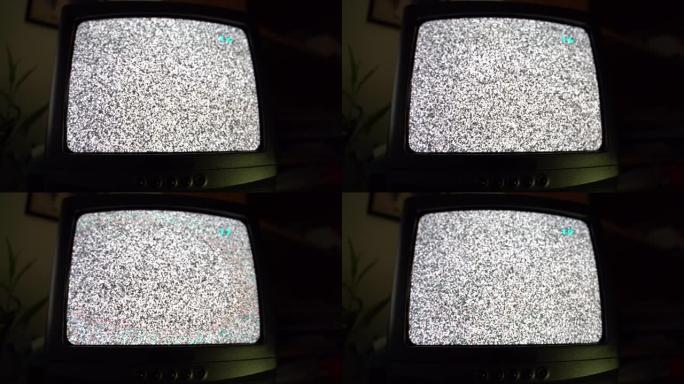 老式复古电视晚上在家庭房间工作，老式电视有噪音静电。在旧电视设备上更改电视频道，屏幕上出现黑白故障。