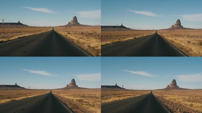 在美国纪念碑谷穿过热沙漠的道路上行驶